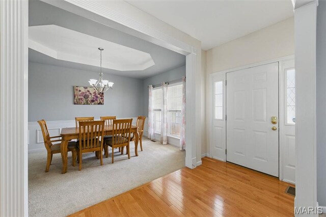 65 Snowberry Ridge Ct, Ofallon, MO 63366 - dining room with light wood finished floors, a chandelier, and a tray ceiling