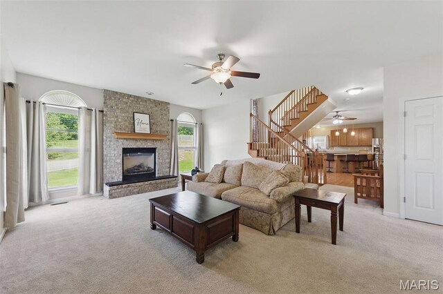 65 Snowberry Ridge Ct, Ofallon, MO 63366 - living area featuring ceiling fan, stairway, carpet, and a brick fireplace