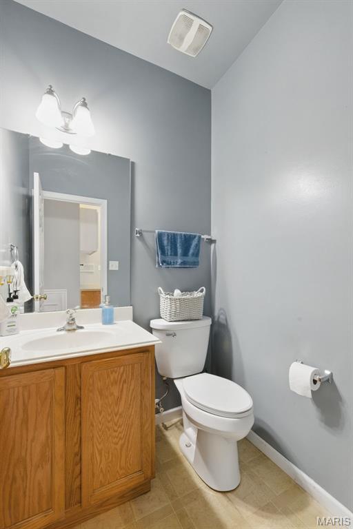 65 Snowberry Ridge Ct, Ofallon, MO 63366 - bathroom featuring toilet, vanity, vaulted ceiling, and baseboards