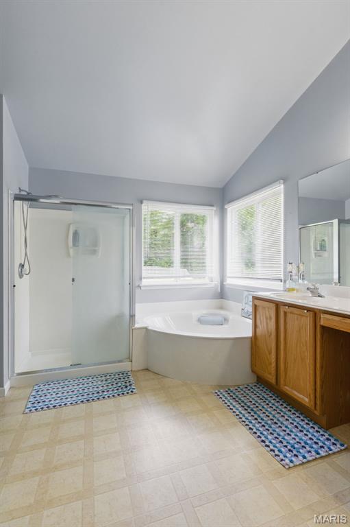 65 Snowberry Ridge Ct, Ofallon, MO 63366 - full bath with vaulted ceiling, a stall shower, a bath, vanity, and tile patterned floors