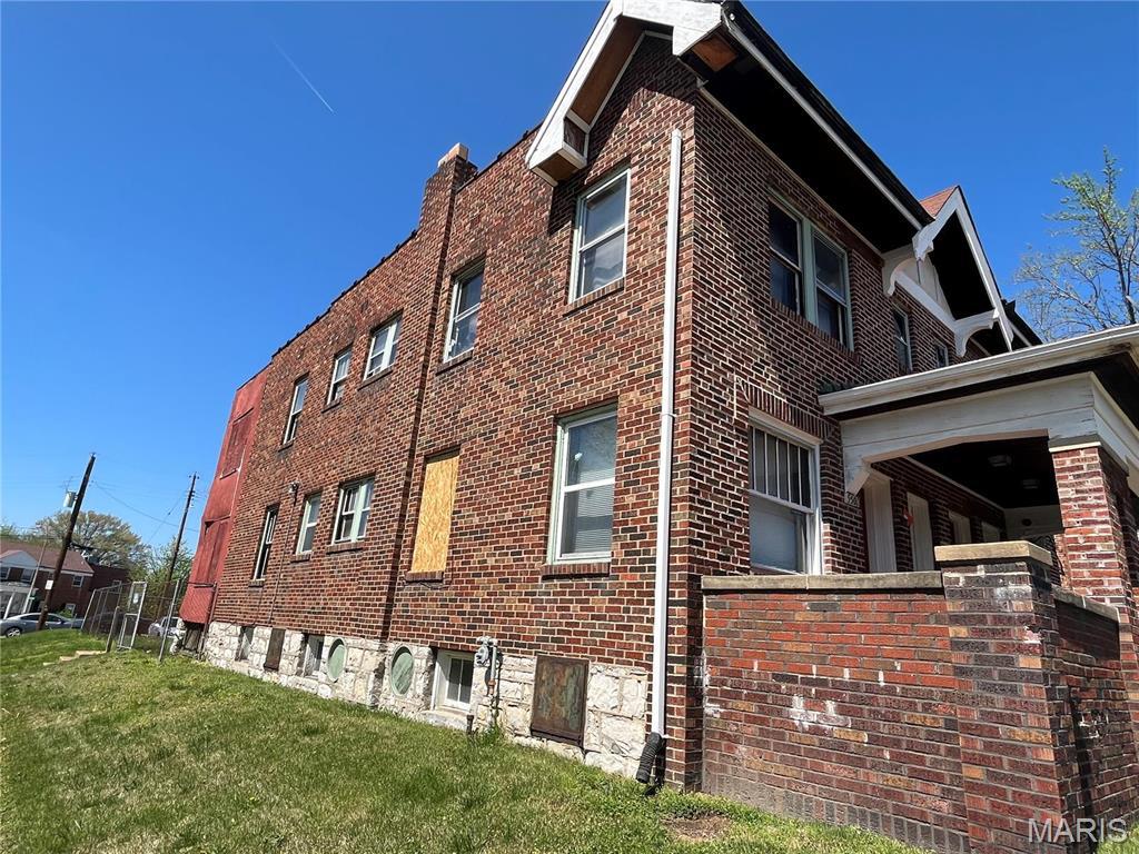 view of home's exterior featuring brick siding and a yard