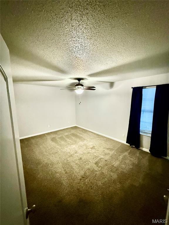 carpeted spare room with ceiling fan, a textured ceiling, and baseboards