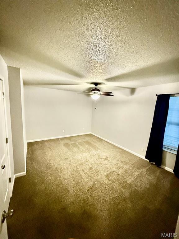 carpeted empty room with ceiling fan, a textured ceiling, and baseboards