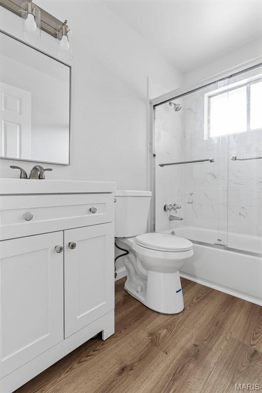 3401 Droste Rd, Saint Charles, MO 63301 - full bath featuring toilet, wood finished floors, shower / bath combination with glass door, and vanity