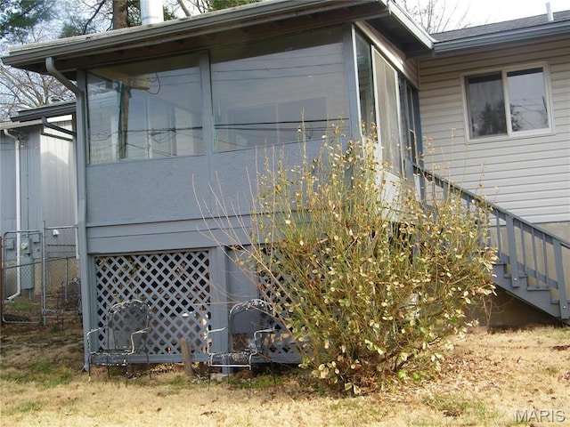 574 Coach Light Ln, Hazelwood, MO 63042 - view of home's exterior with a sunroom, fence, and stairway