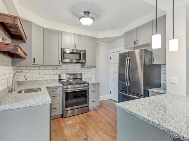 2907 S Kingshighway Blvd, Saint Louis, MO 63139 - kitchen with stainless steel appliances, gray cabinetry, a sink, light stone countertops, and decorative backsplash