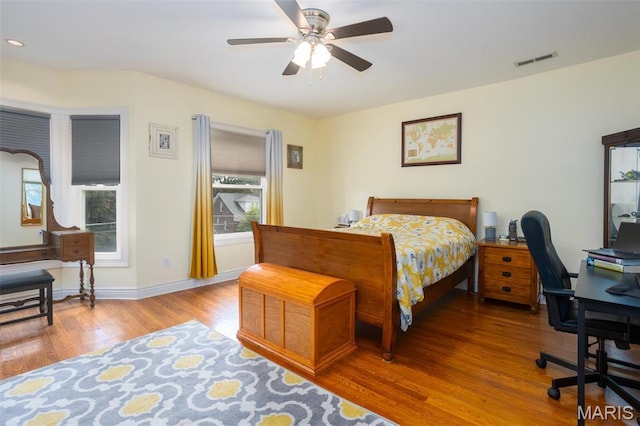 bedroom featuring wood finished floors, an office area, a ceiling fan, baseboards, and recessed lighting