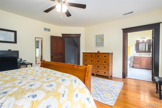 bedroom featuring light wood-style flooring, connected bathroom, and a ceiling fan