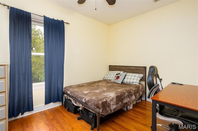 bedroom featuring wood finished floors, ceiling fan, and a desk