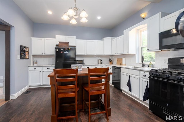 kitchen with black appliances, a sink, a chandelier, tasteful backsplash, and dark wood finished floors