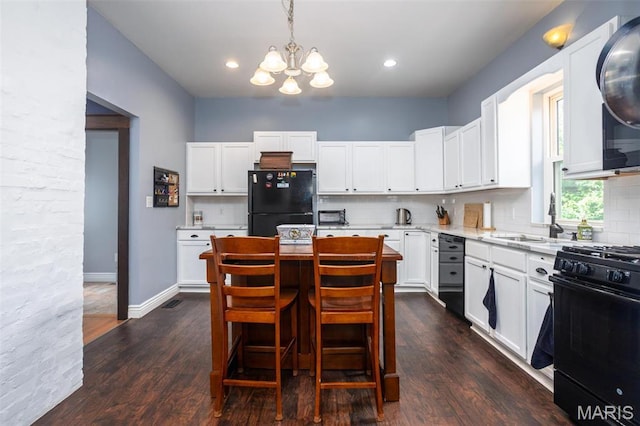 kitchen with black appliances, a chandelier, a sink, tasteful backsplash, and white cabinetry