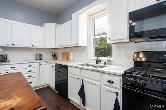 kitchen featuring black appliances, a sink, dark wood-style flooring, and tasteful backsplash