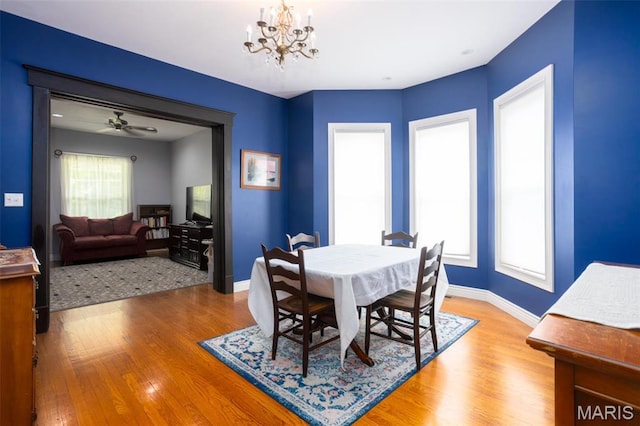 dining room with a chandelier, wood finished floors, and baseboards