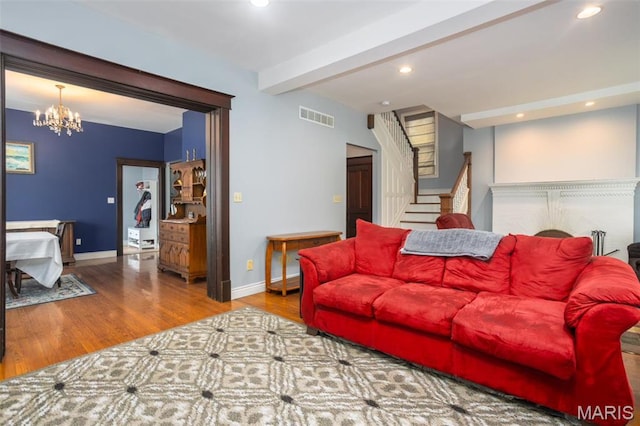 living area with wood finished floors, stairs, a chandelier, recessed lighting, and baseboards