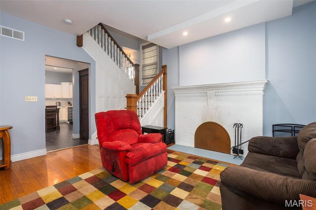 living area with wood finished floors, stairs, recessed lighting, and baseboards