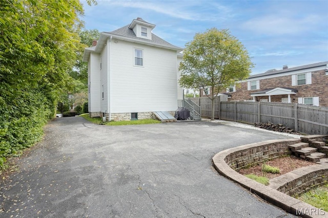 view of side of property with fence and a patio