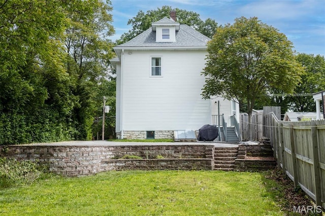 back of property with a chimney and roof with shingles