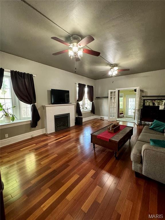 149 N Elizabeth Ave, Saint Louis, MO 63135 - living room featuring ceiling fan, wood-type flooring, healthy amount of natural light, a fireplace, and a textured ceiling