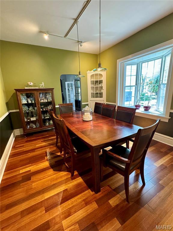 149 N Elizabeth Ave, Saint Louis, MO 63135 - dining space featuring rail lighting, wood finished floors, and baseboards