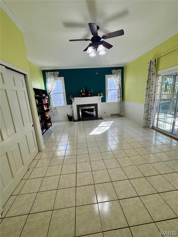 149 N Elizabeth Ave, Saint Louis, MO 63135 - living area featuring crown molding, light tile patterned floors, healthy amount of natural light, ceiling fan, and a brick fireplace