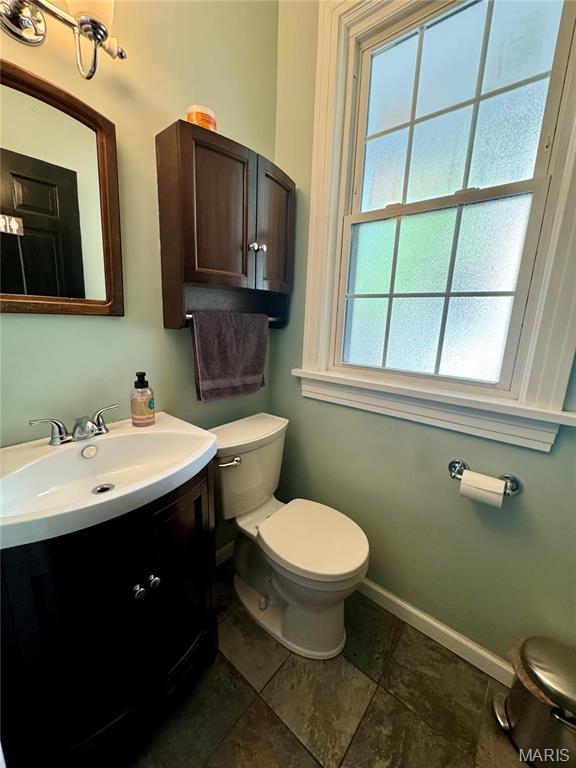 149 N Elizabeth Ave, Saint Louis, MO 63135 - half bathroom with baseboards, vanity, and toilet