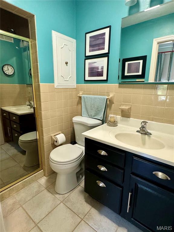 149 N Elizabeth Ave, Saint Louis, MO 63135 - full bath with toilet, tile walls, vanity, tile patterned flooring, and a shower stall