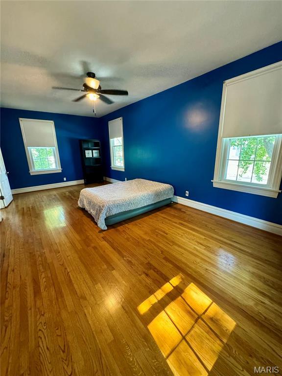 149 N Elizabeth Ave, Saint Louis, MO 63135 - bedroom with multiple windows, wood finished floors, and baseboards