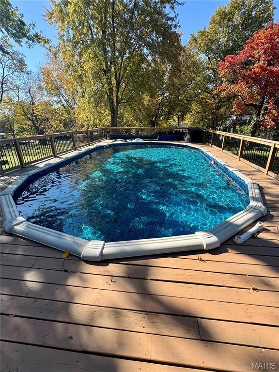 149 N Elizabeth Ave, Saint Louis, MO 63135 - view of swimming pool with a wooden deck and view of wooded area