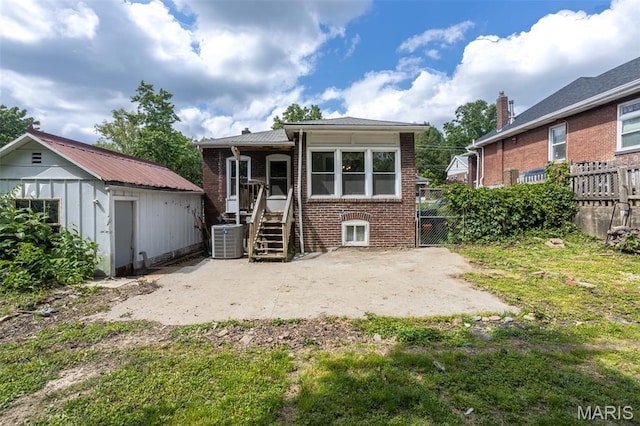 7434 Gayola Pl, Saint Louis, MO 63143 - back of property featuring central air condition unit, brick siding, fence, an outdoor structure, and a patio