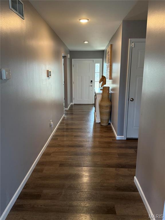 corridor with baseboards and dark wood-style flooring