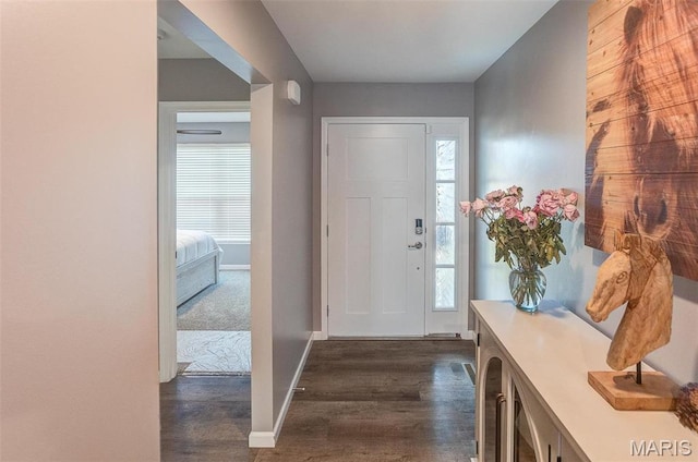 foyer with dark wood-style floors and baseboards