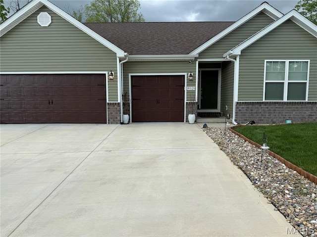 view of front facade featuring an attached garage, brick siding, and concrete driveway