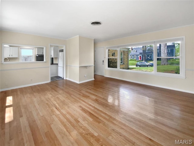246 Barter Ave, Saint Louis, MO 63122 - unfurnished living room with light wood-type flooring, baseboards, and a sink