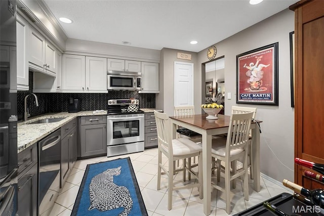 2013 Trailcrest Ln Unit 7, Saint Louis, MO 63122 - kitchen with appliances with stainless steel finishes, a sink, tasteful backsplash, light stone counters, and light tile patterned floors