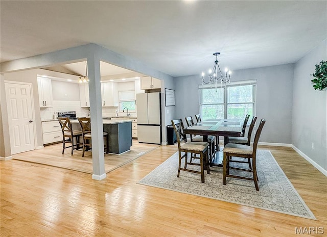 504 Leawood Dr, Swansea, IL 62226 - dining area with a chandelier, light wood finished floors, and baseboards