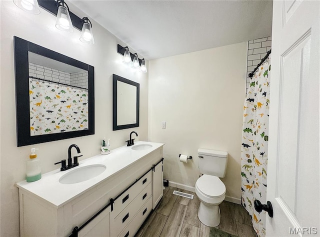 504 Leawood Dr, Swansea, IL 62226 - bathroom with wood tiled floors, toilet, double vanity, baseboards, and a shower with curtain
