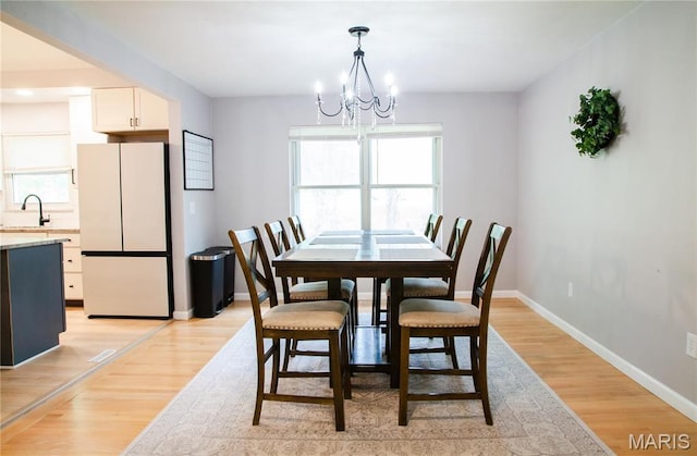 504 Leawood Dr, Swansea, IL 62226 - dining space with a chandelier, healthy amount of natural light, light wood-style floors, and baseboards
