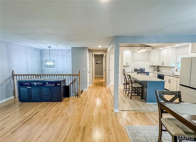 504 Leawood Dr, Swansea, IL 62226 - kitchen featuring electric stove, freestanding refrigerator, a chandelier, white cabinets, and a center island
