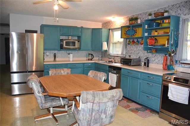 258 Hideaway Trl, Eureka, MO 63025 - kitchen with appliances with stainless steel finishes, a textured ceiling, light countertops, a ceiling fan, and blue cabinetry