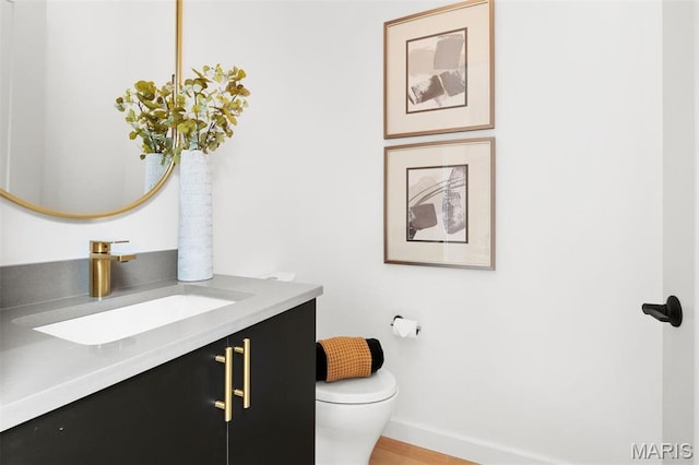215 N Sarah St Unit 12, Saint Louis, MO 63108 - half bath featuring toilet, vanity, baseboards, and wood finished floors