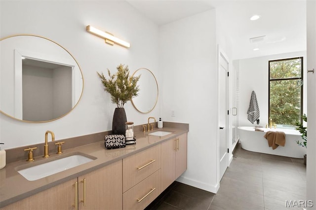 215 N Sarah St Unit 12, Saint Louis, MO 63108 - full bath with tile patterned flooring, double vanity, a freestanding tub, baseboards, and recessed lighting