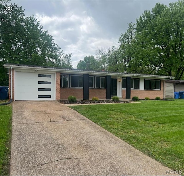 2530 N Waterford Dr, Florissant, MO 63033 - view of front of home with brick siding, an attached garage, driveway, and a front lawn
