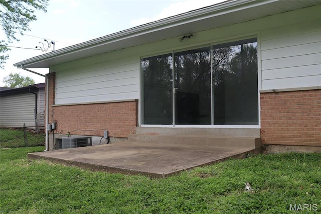 2530 N Waterford Dr, Florissant, MO 63033 - rear view of house featuring central AC, entry steps, brick siding, and a patio area