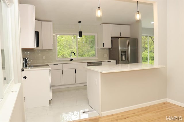 2530 N Waterford Dr, Florissant, MO 63033 - kitchen featuring appliances with stainless steel finishes, a sink, backsplash, and light countertops