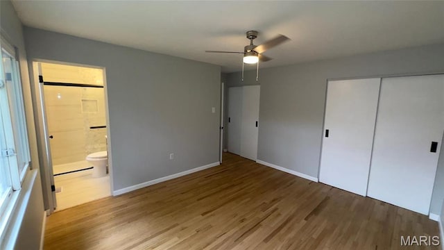 2530 N Waterford Dr, Florissant, MO 63033 - unfurnished bedroom with wood finished floors, a closet, baseboards, ensuite bathroom, and ceiling fan