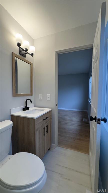 2530 N Waterford Dr, Florissant, MO 63033 - bathroom featuring toilet, vanity, and baseboards