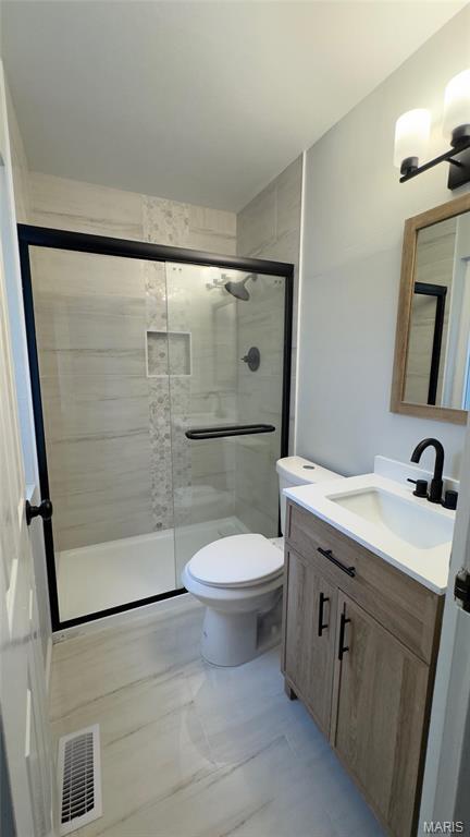 2530 N Waterford Dr, Florissant, MO 63033 - full bath with a stall shower, vanity, toilet, and marble finish flooring
