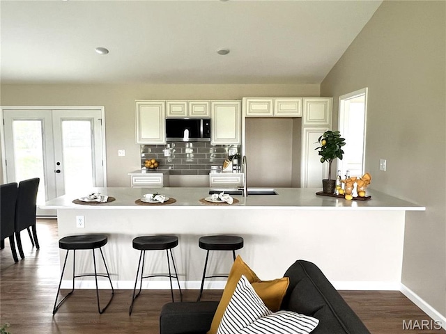 201 S Ashbrook, Bethalto, IL 62010 - kitchen with stainless steel microwave, a sink, a kitchen bar, tasteful backsplash, and dark wood finished floors