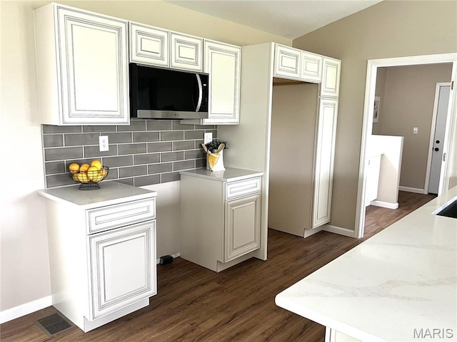 201 S Ashbrook, Bethalto, IL 62010 - kitchen featuring stainless steel microwave, dark wood-style flooring, backsplash, baseboards, and white cabinets
