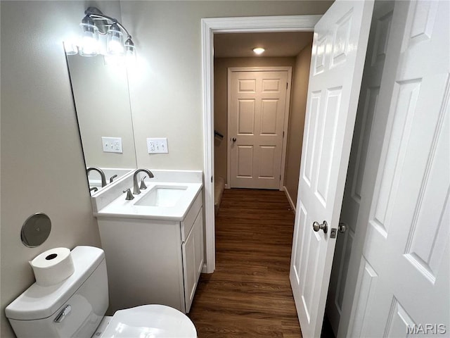 201 S Ashbrook, Bethalto, IL 62010 - half bathroom featuring wood finished floors, toilet, vanity, and baseboards
